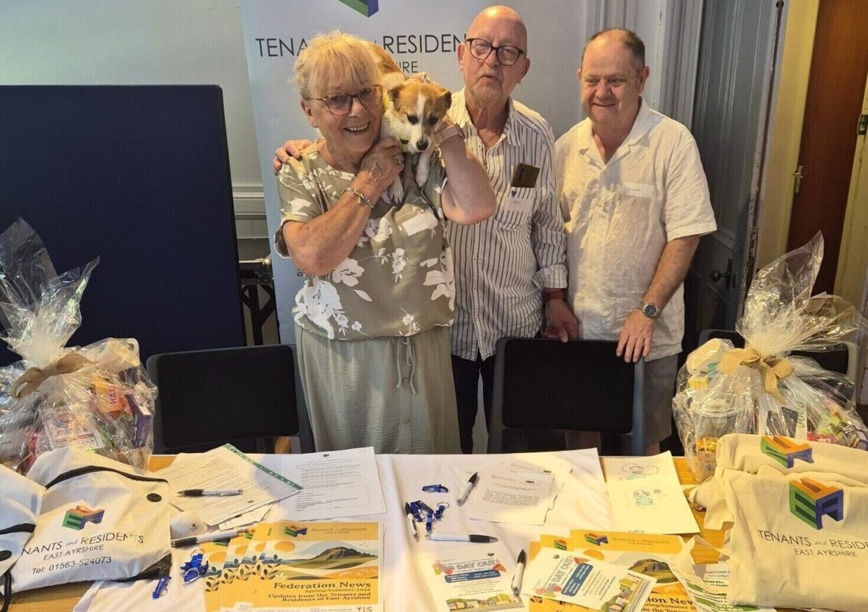 Three smiling Fed Members at Federation Stall with a dog on Alicia's shoulders